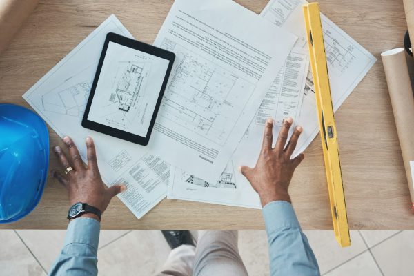 Architecture, person hands and blueprint planning, construction design and renovation on desk above